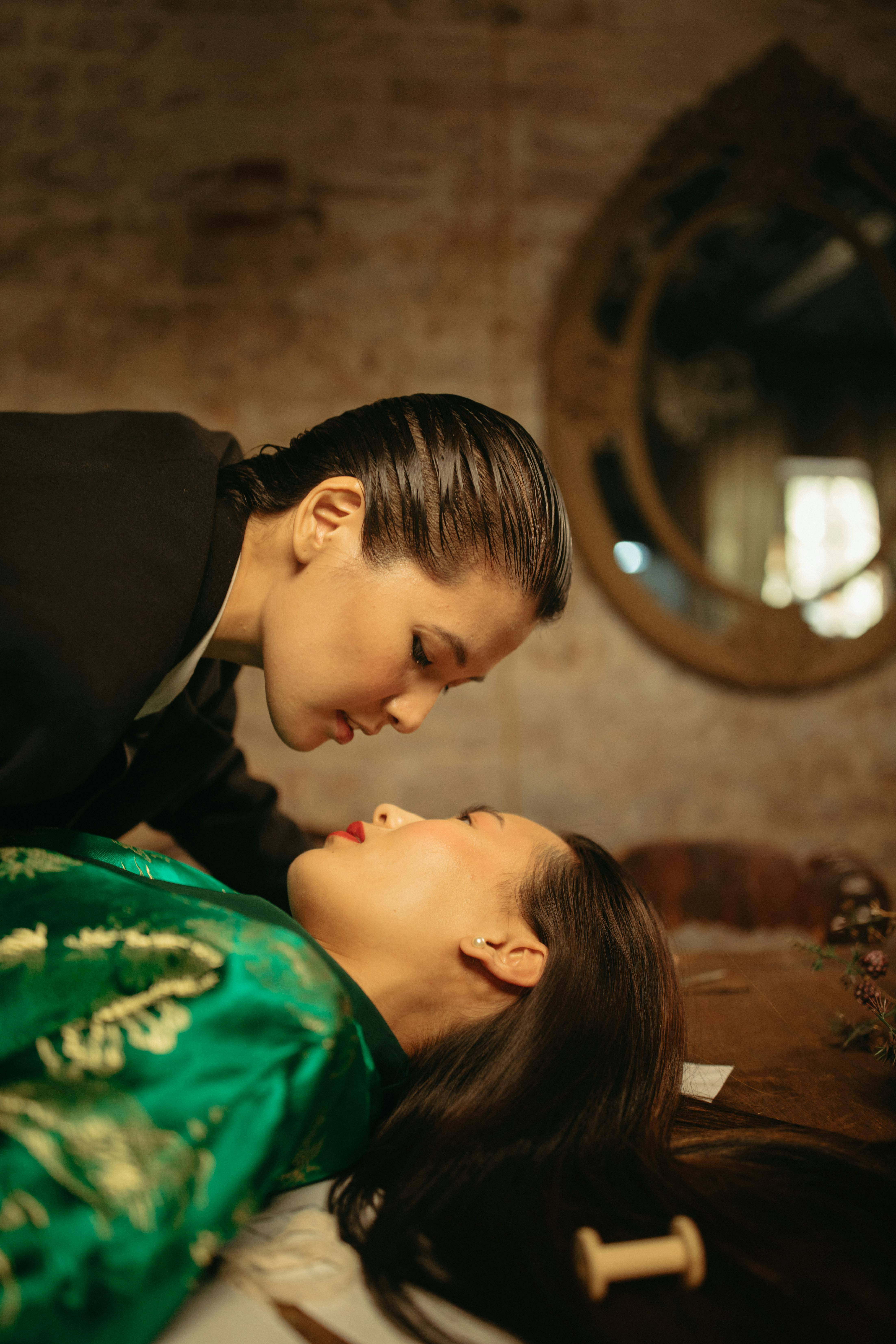 boy in black shirt kissing woman in green shirt