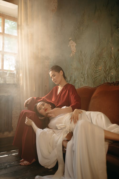 Women Wearing Kimonos Lying on Sofa in Sunlight 