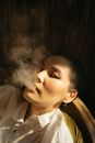 Close-Up Photo of a Woman in a White Collared Shirt Smoking