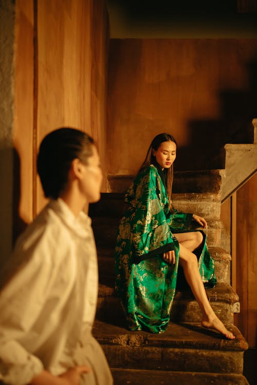A Woman in Green Kimono Sitting on Stairs