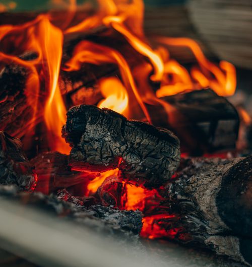 Free Detailed view of burning wood with vibrant flames and glowing embers, capturing the essence of warmth and coziness. Stock Photo