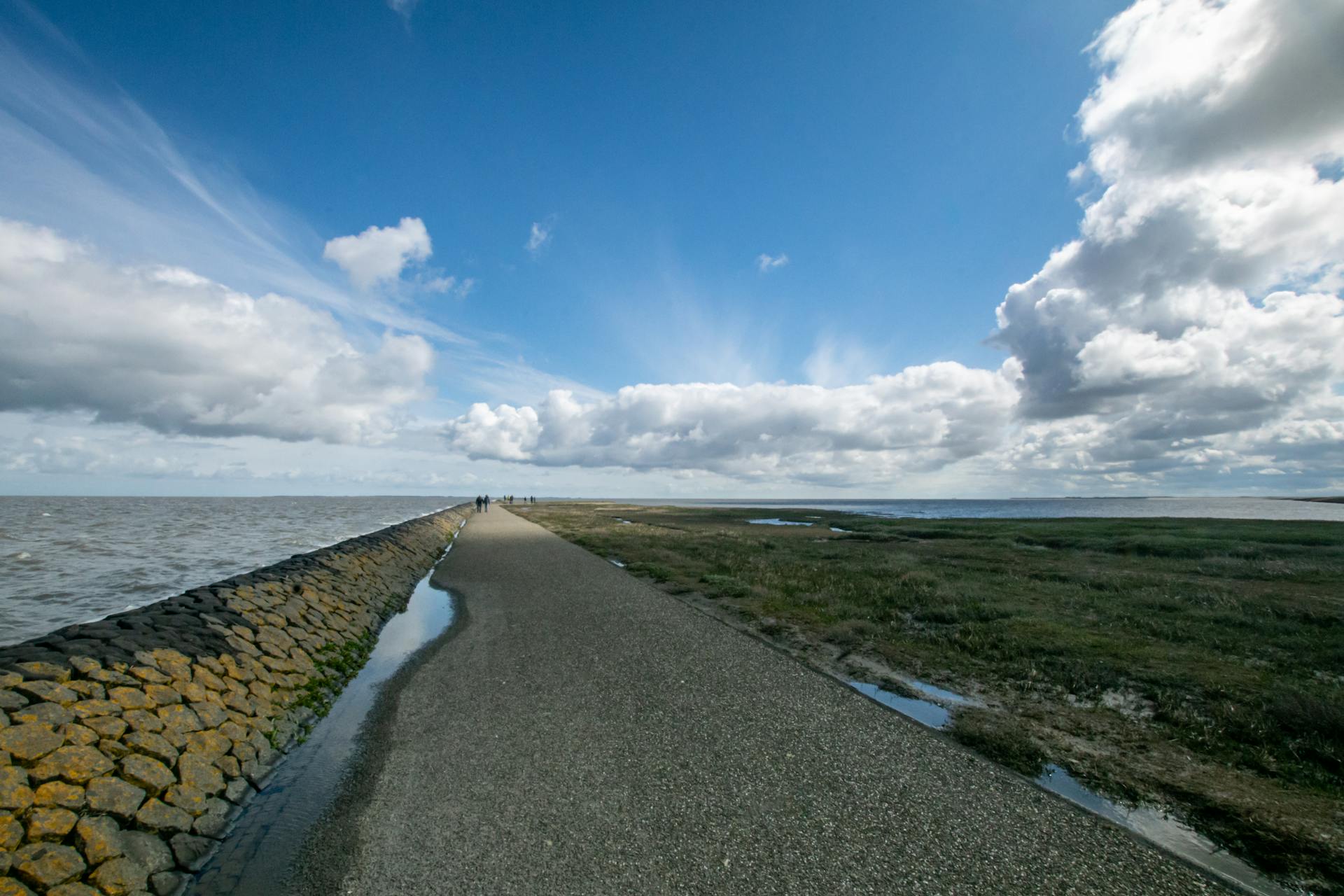 A scenic coastal pathway with a vast open sky and sea, perfect for nature walks.