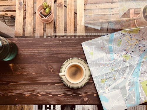 Cup of Coffee on a Saucer Beside a Map