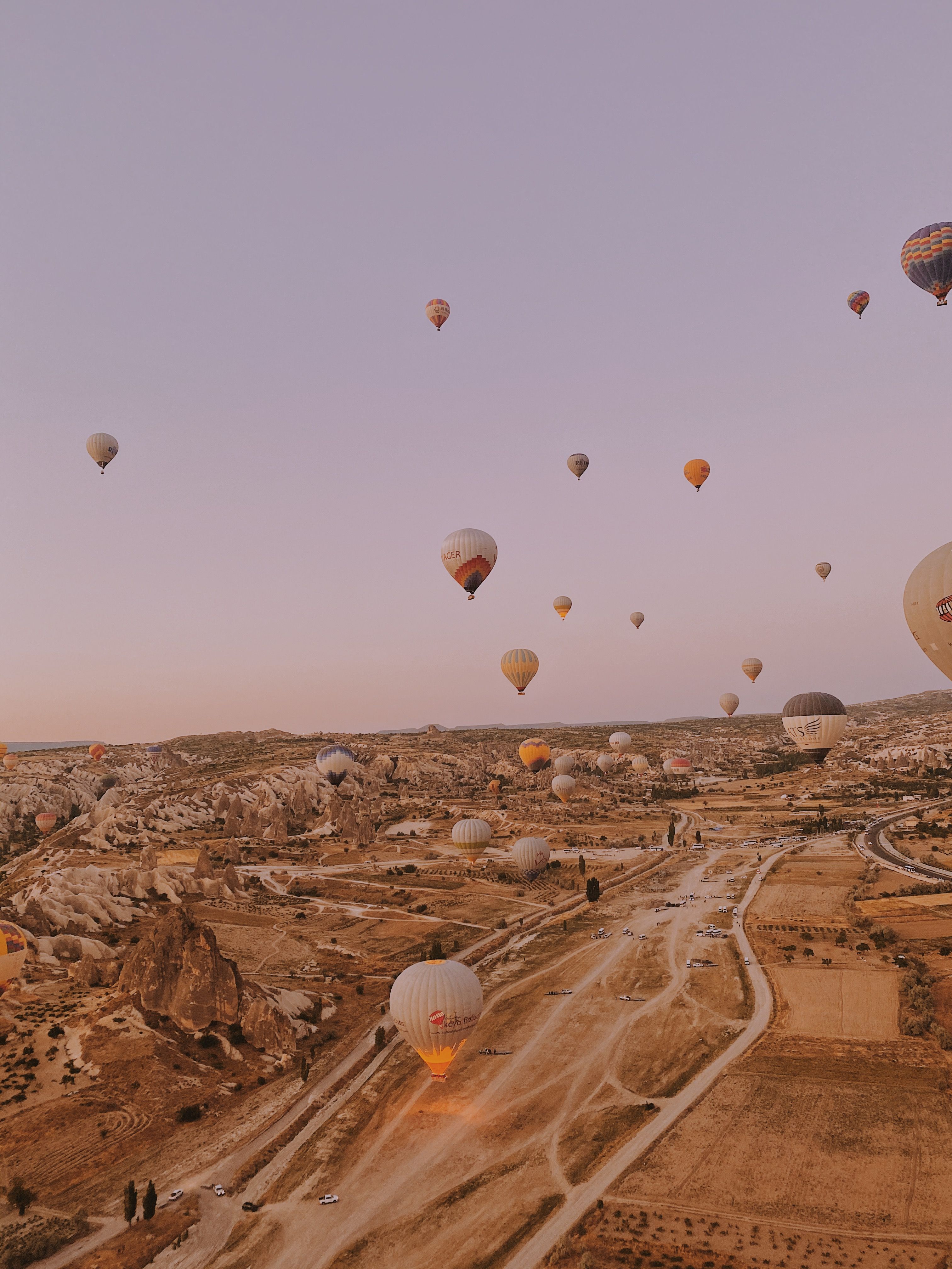 Scenic view of hot air balloons over the rocky landscape of Cappadocia, Turkey, at sunrise.