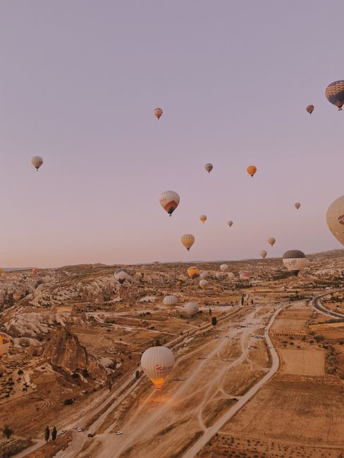 Scenic view of hot air balloons over the rocky landscape of Cappadocia, Turkey, at sunrise.