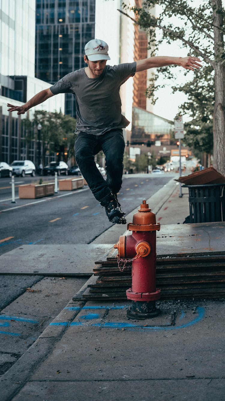 Man Wearing Rollerblades Jumping Near Fire Hydrant