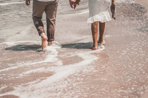 Man and Woman Walking on Beach