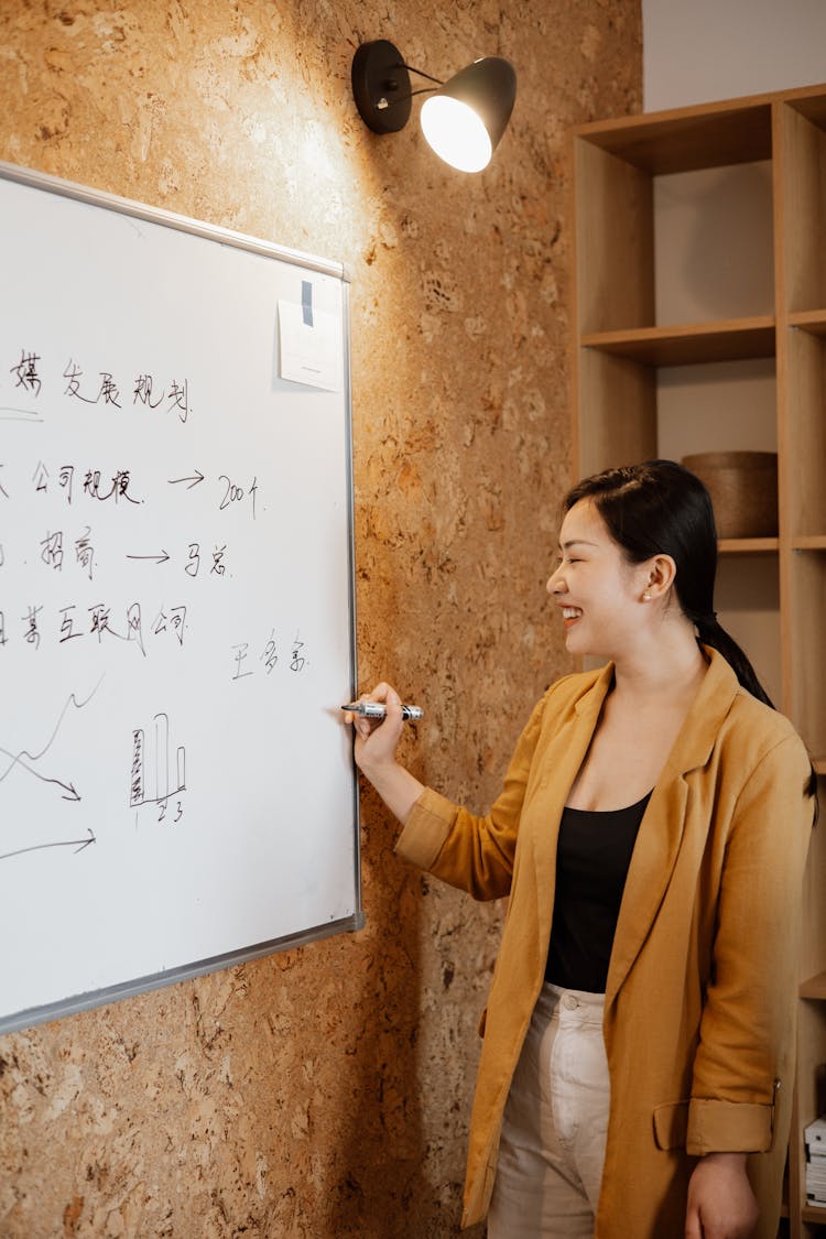 Woman Smiling While Presenting At The Office