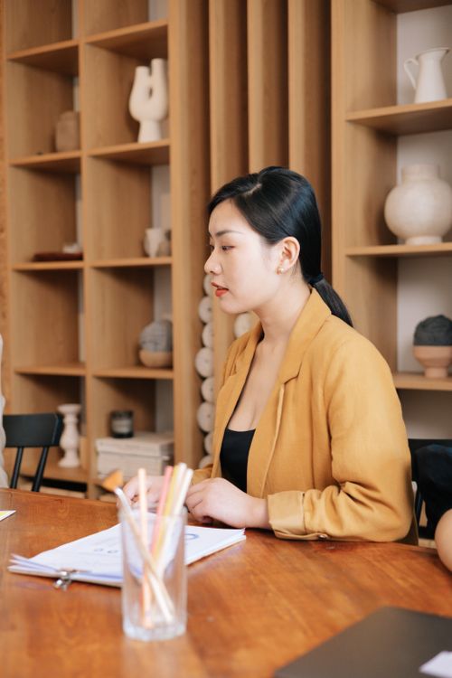 Free Asian woman in office attire working at a desk, highlighting a professional work environment. Stock Photo