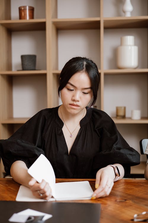 Free Woman in Black Long Sleeve Shirt Holding Her Notebook Stock Photo