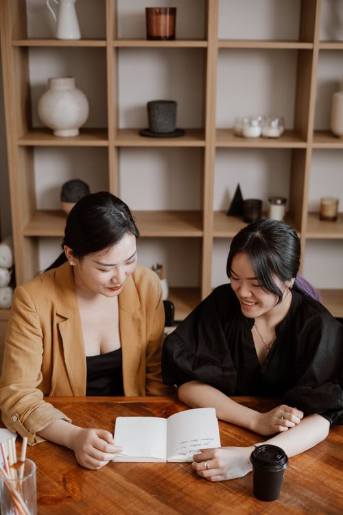 Free Two young women engaged in a creative meeting at a stylish workspace. Stock Photo
