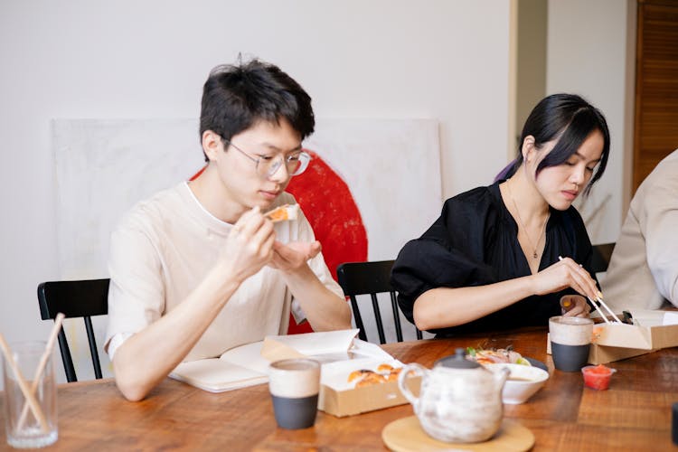 Man And Woman Eating With Chopsticks