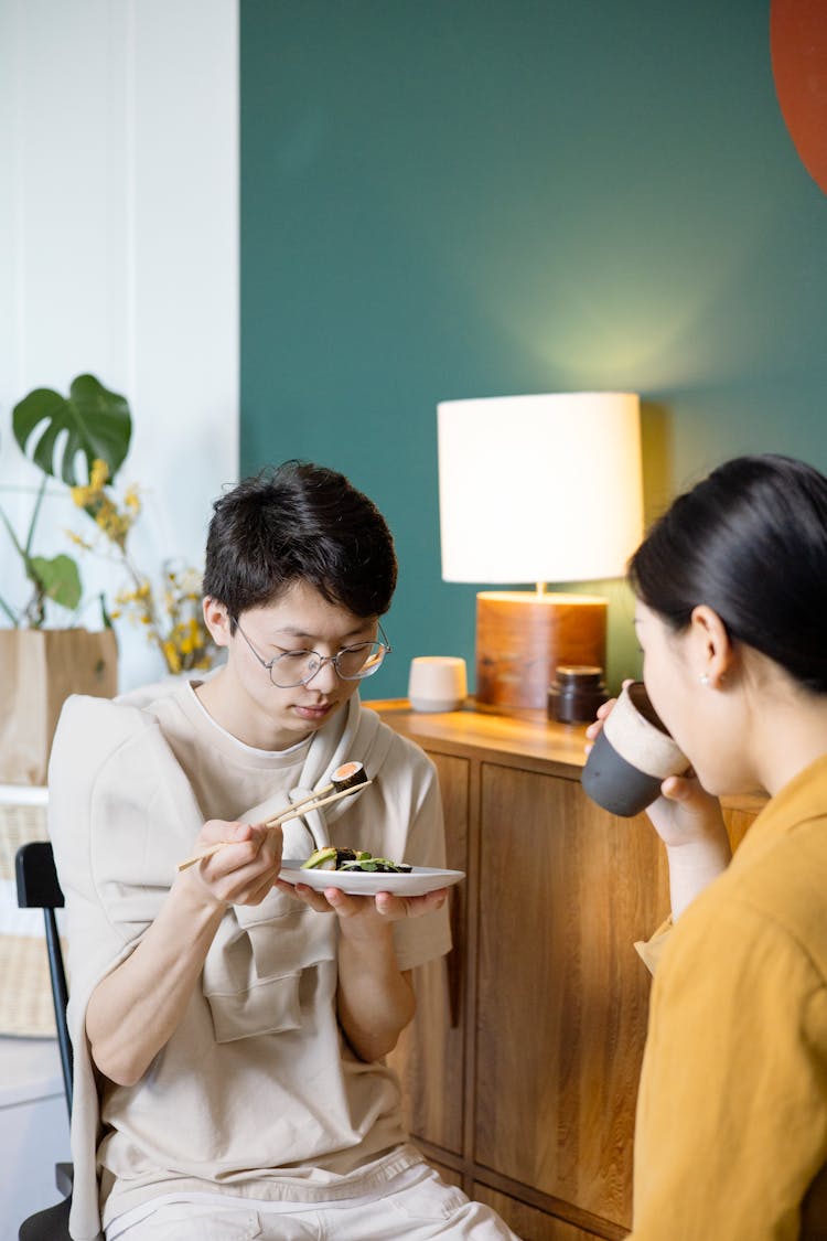 Man Wearing Eyeglasses Eating With Chopsticks