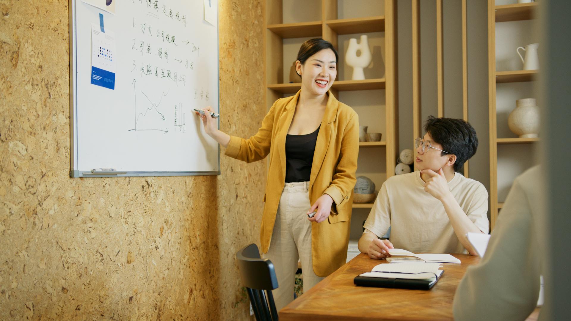 A diverse team discussing strategies in a modern office setting, focusing on whiteboard presentations.