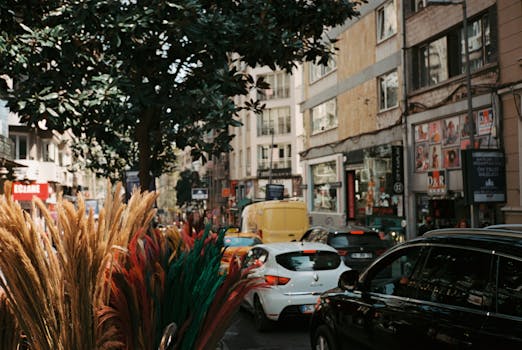Vibrant city street with traffic jam, showcasing colorful decorations and urban life.