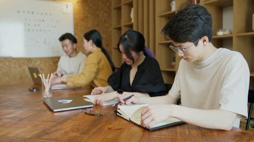 People Working on Laptops by the Wooden Desk