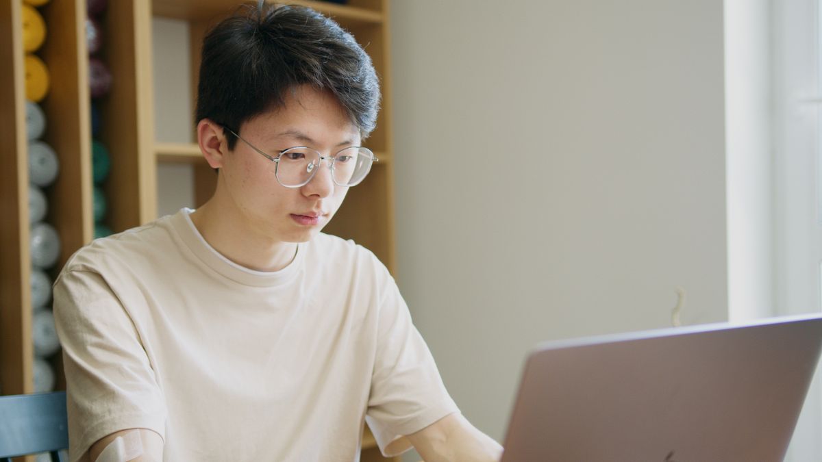 현대적인 실내 환경에서 노트북에 코드를 타이핑하는 여성, 기술 작업 보여주기