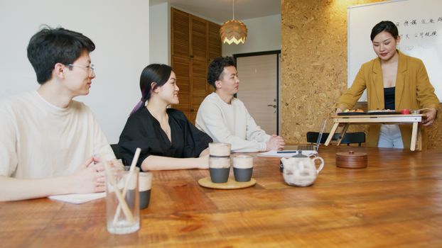 Business colleagues enjoying a sushi lunch during a casual meeting in a modern office setting.
