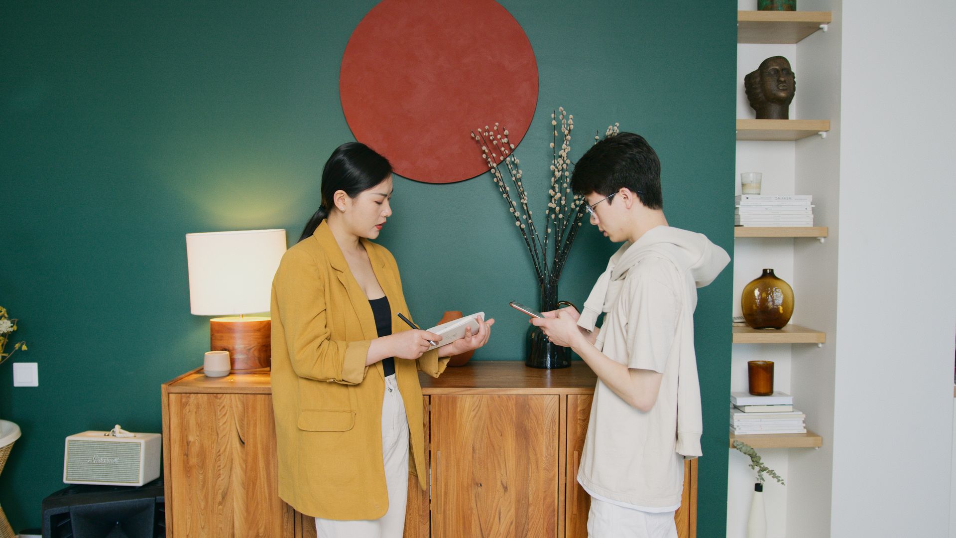Two business professionals discuss using mobile devices in a modern office setting.