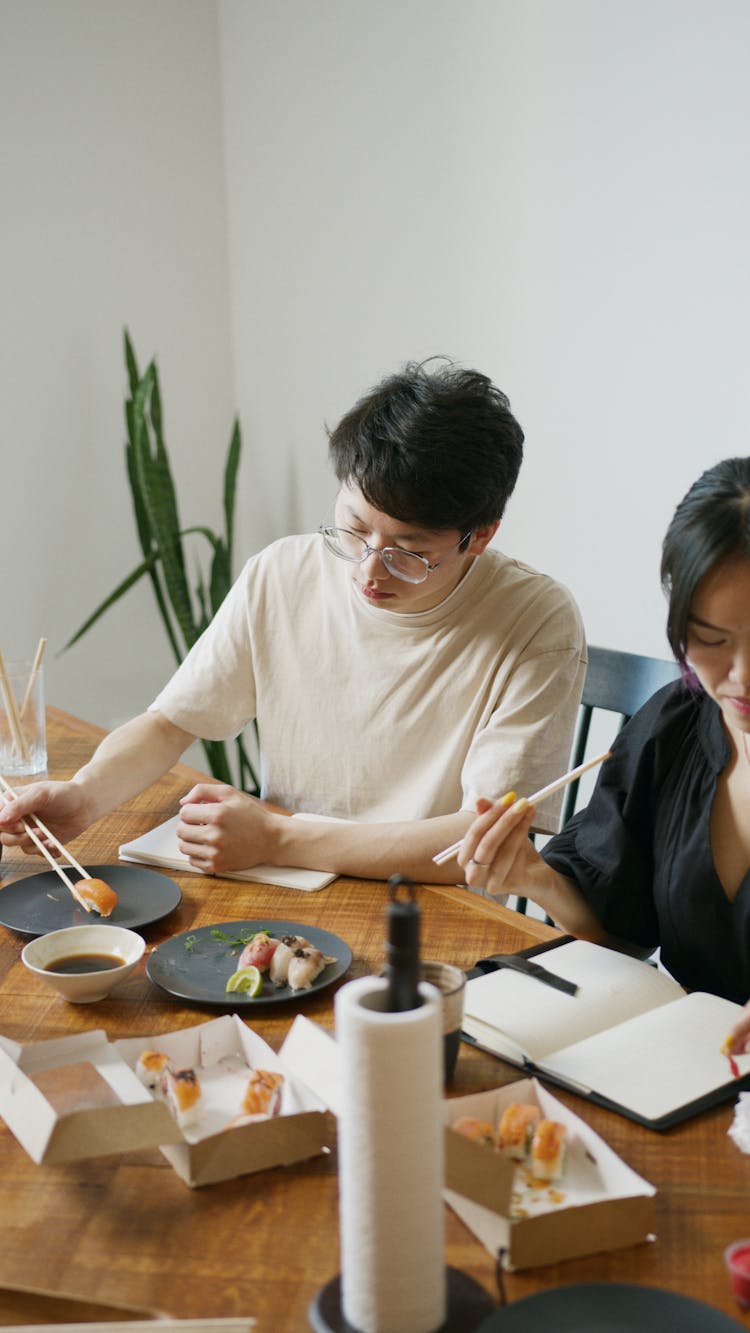 A Man And A Woman Eating Sushi 