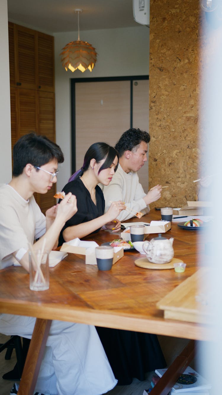 A Family Eating Lunch On A Wooden Table