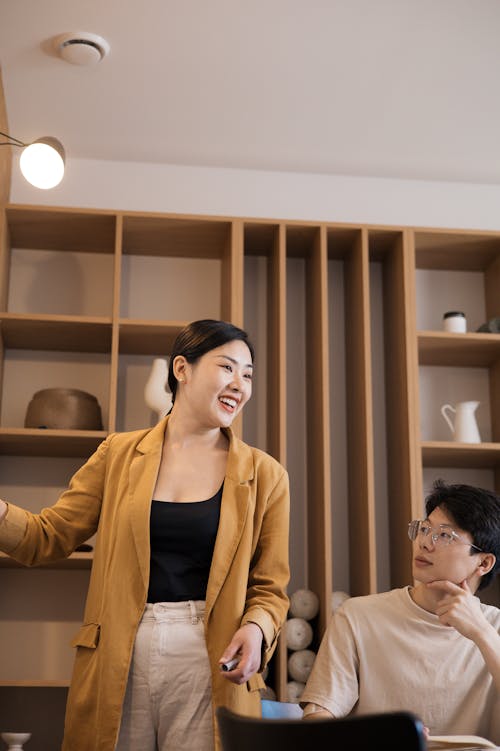 Woman in Brown Coat Discussing in a Meeting