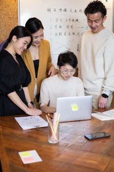 Group of diverse professionals collaborating on a project in an office meeting room.