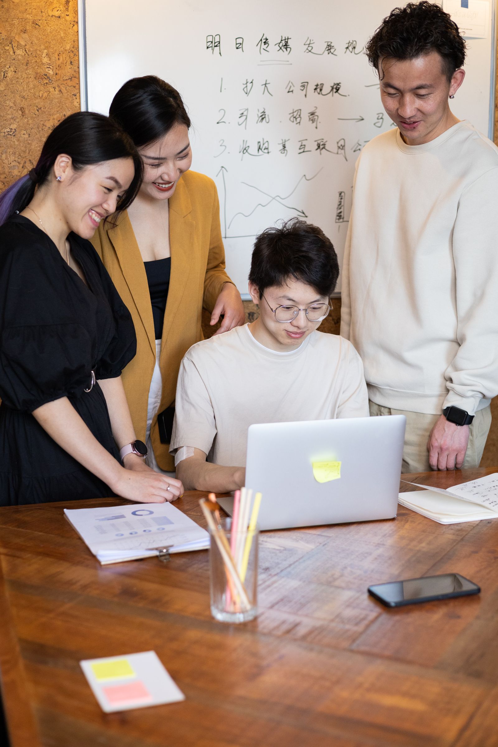 A team gathered around a table reviewing work together