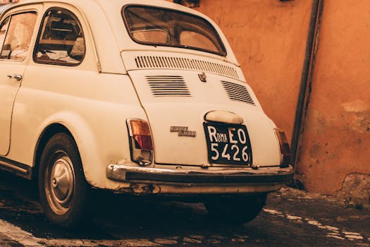 罗马的鹅卵石街道上，停着一辆经典的菲亚特500，给人一种复古的感觉