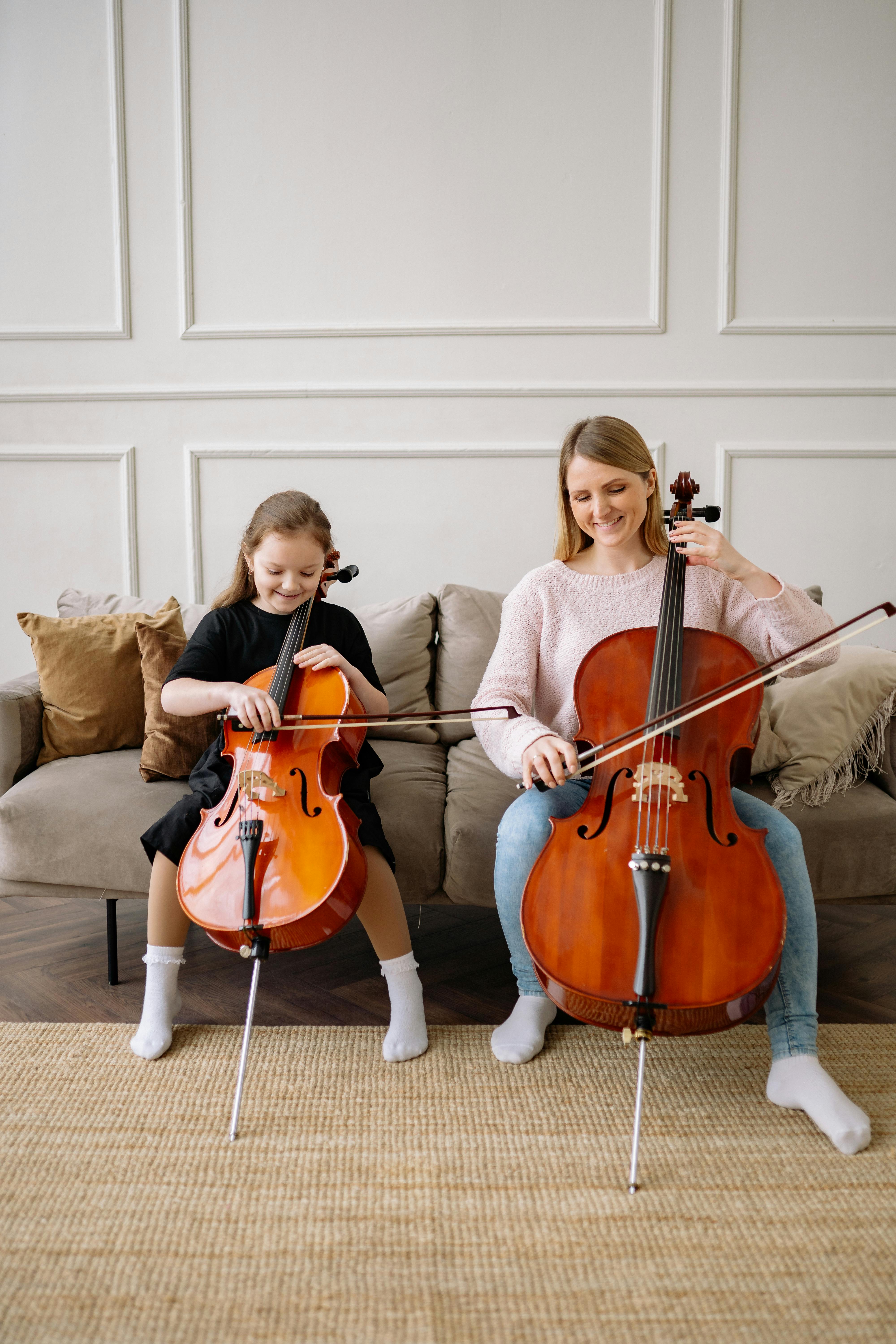 a woman and a girl playing cello