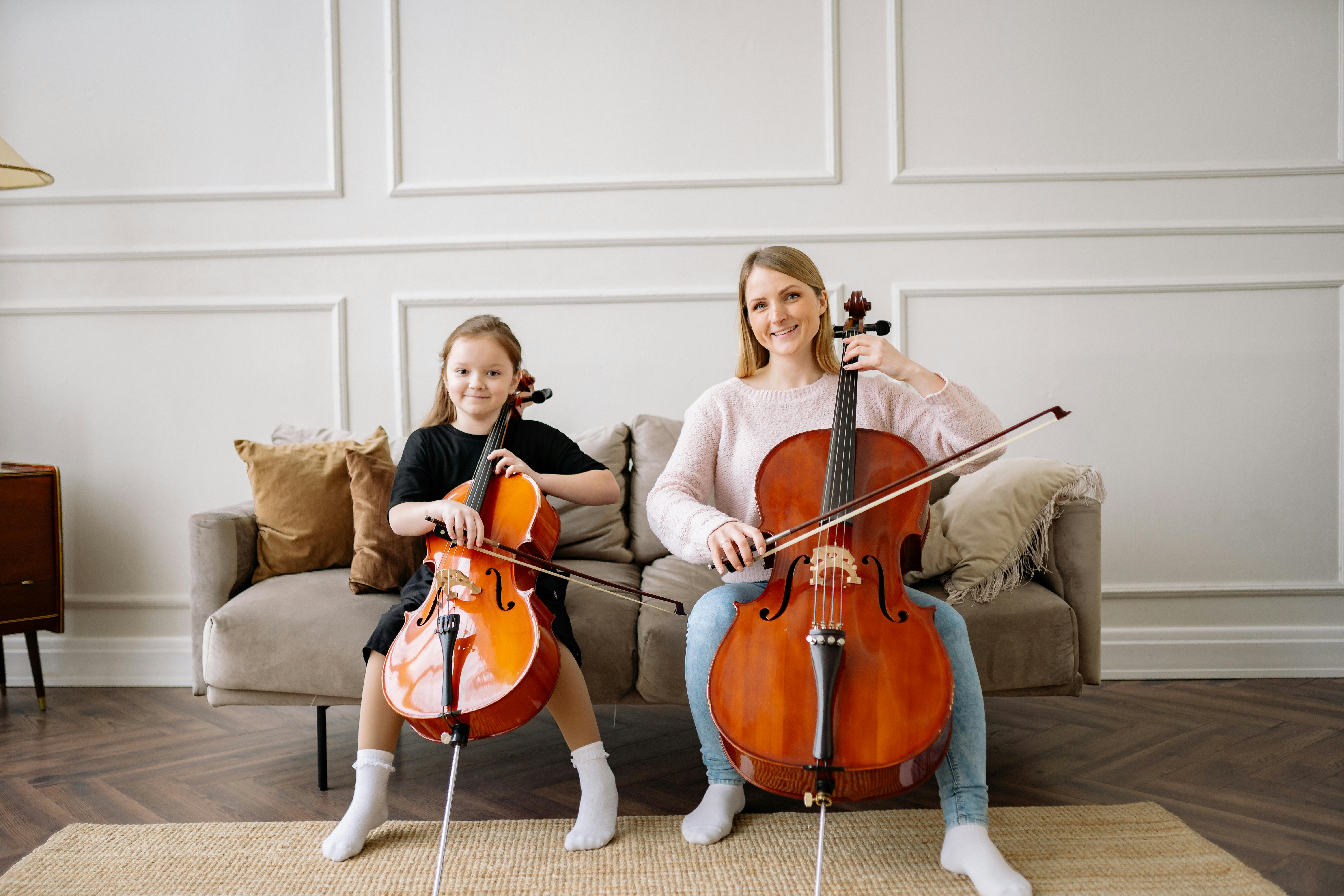 a woman and a girl playing cello