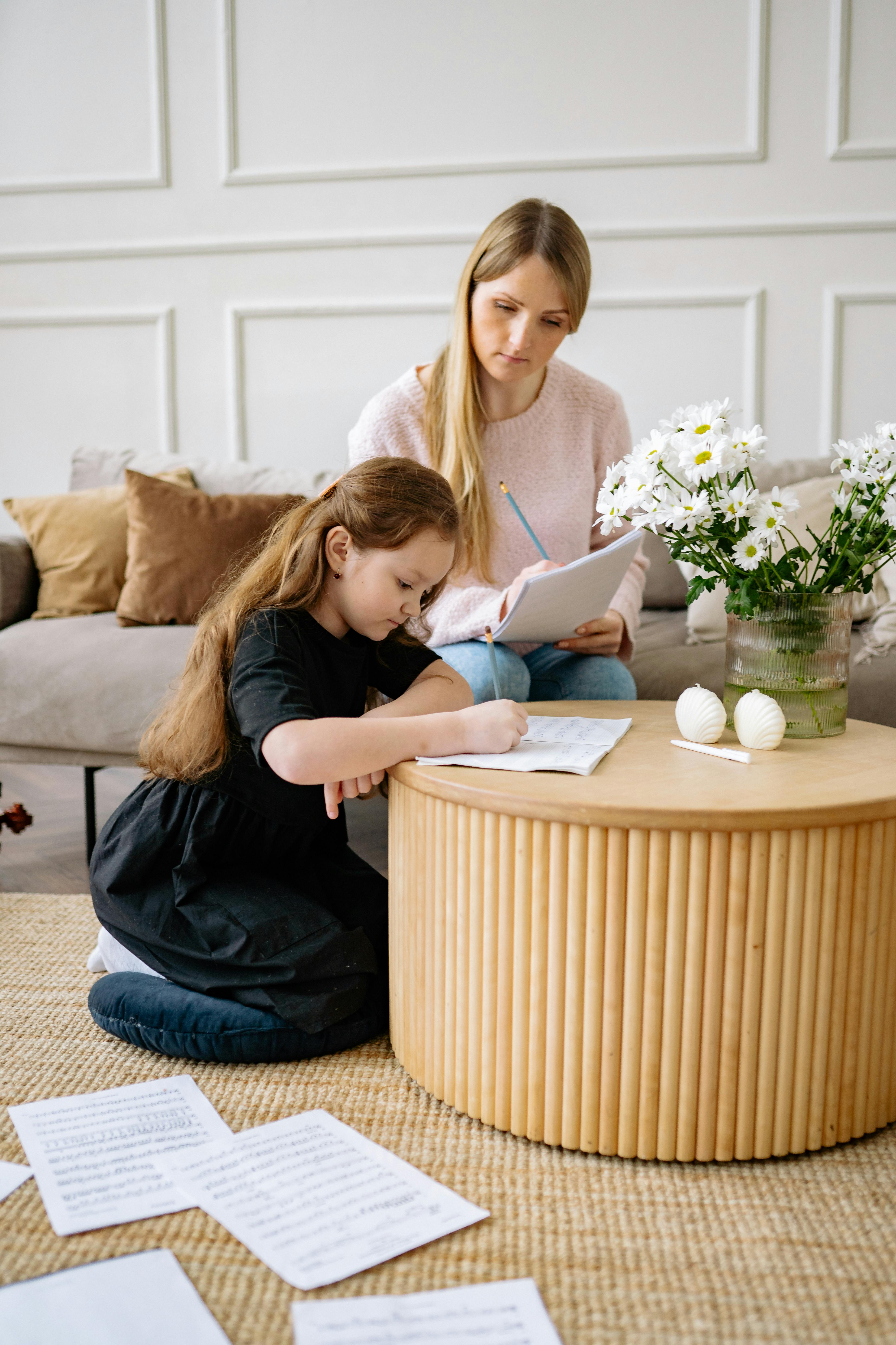 mother looking at her daughter study