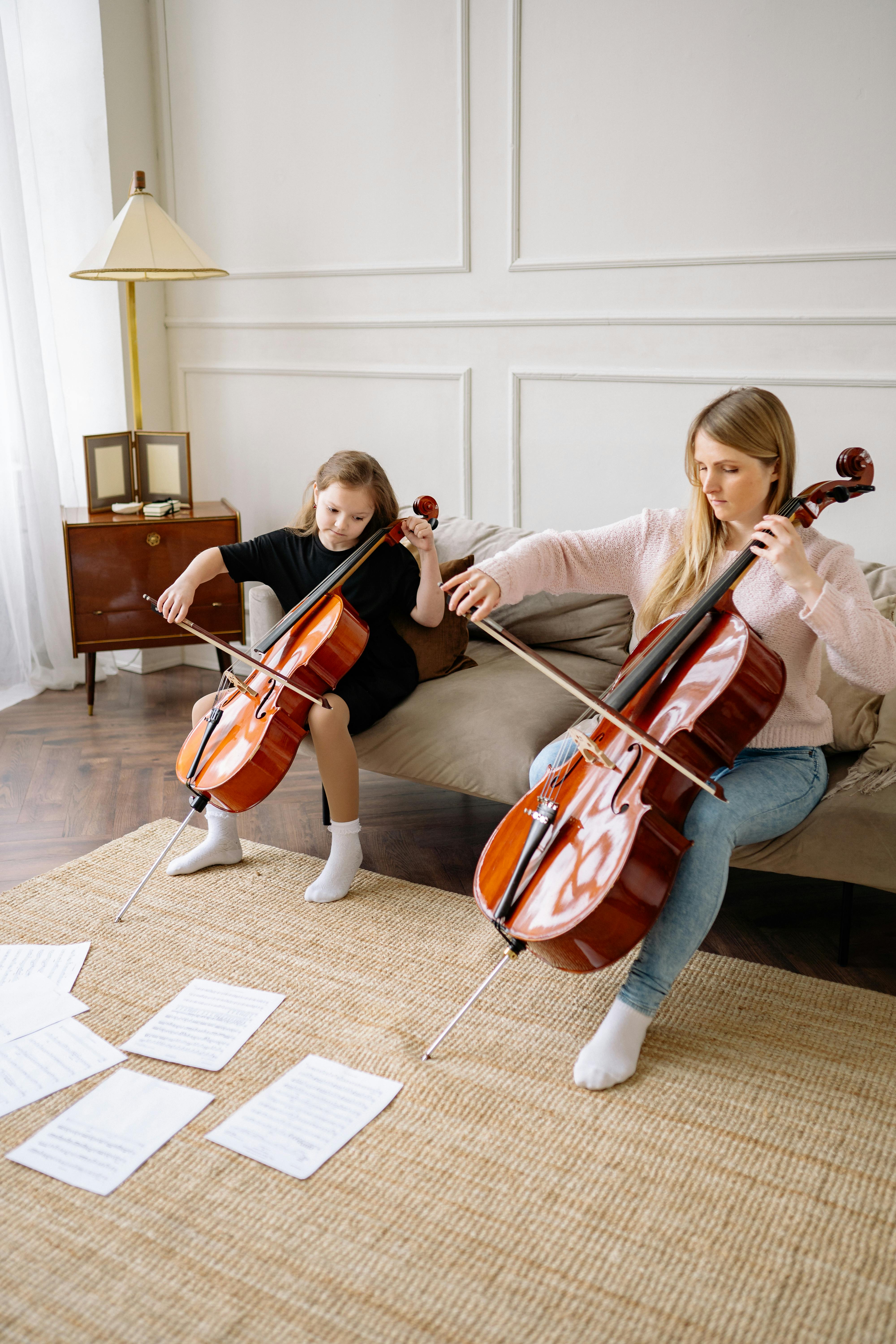 a woman and a girl playing cello