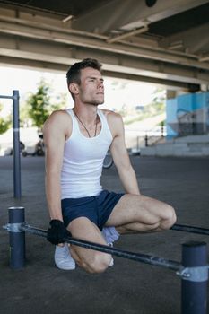 Man in White Tank Top and Black Shorts Sitting on Bench