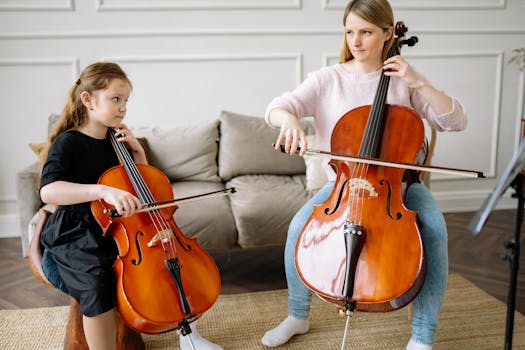 A mother and daughter duo playing cellos together indoors in a cozy room setting.