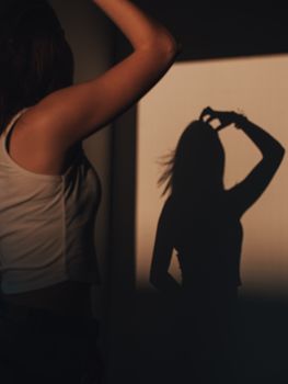 A woman casts a silhouette on the wall, creating an artistic play of light and shadow.