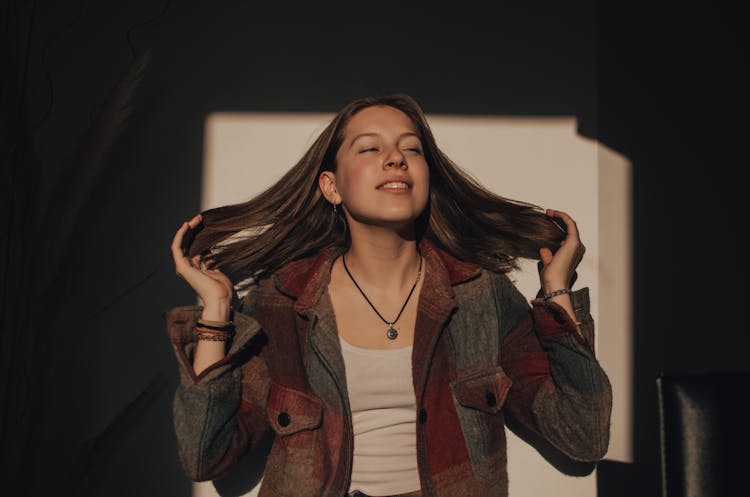 Woman In Checkered Jacket Fixing Her Hair