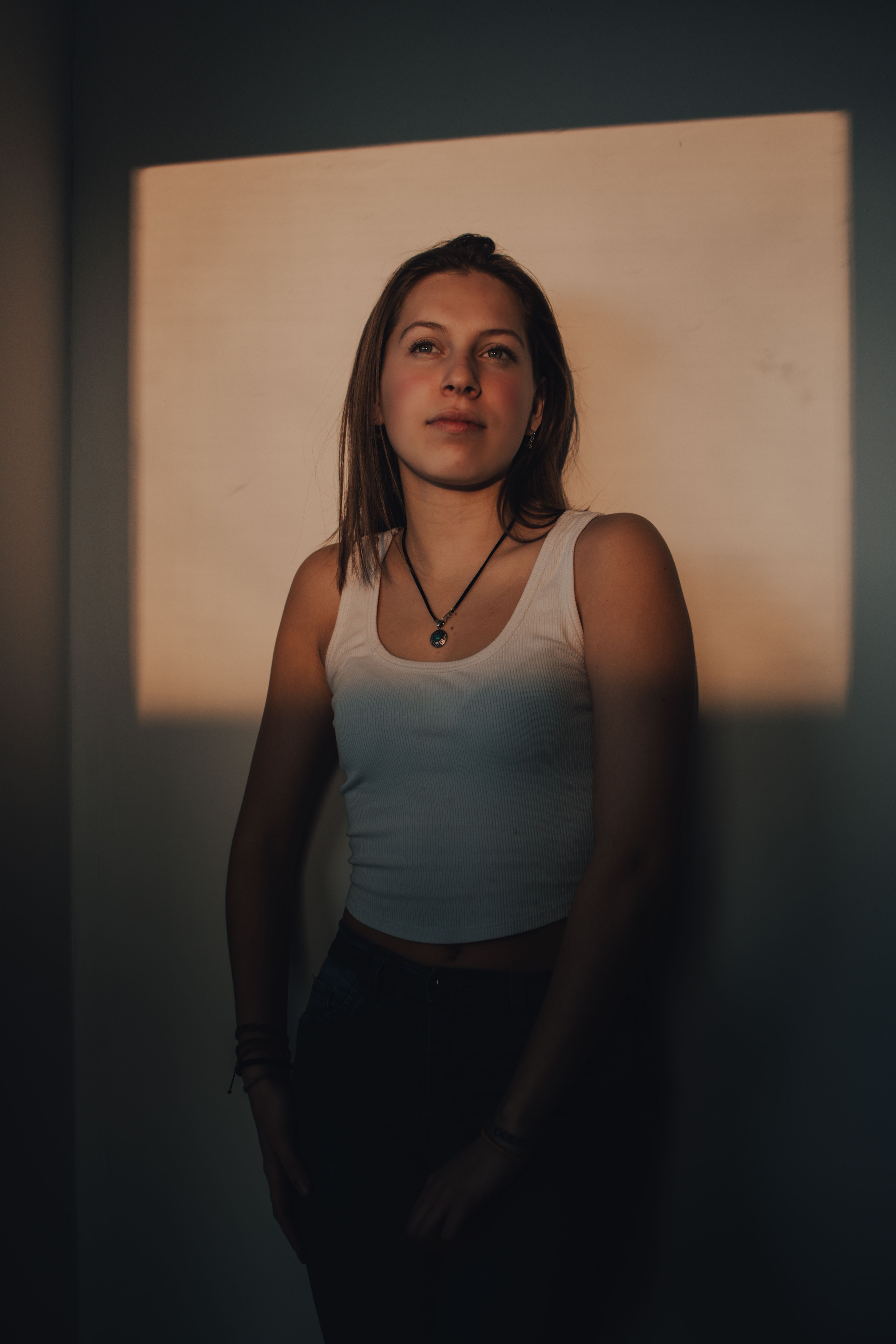 Woman in White Tank Top Standing Against a Wall · Free Stock Photo