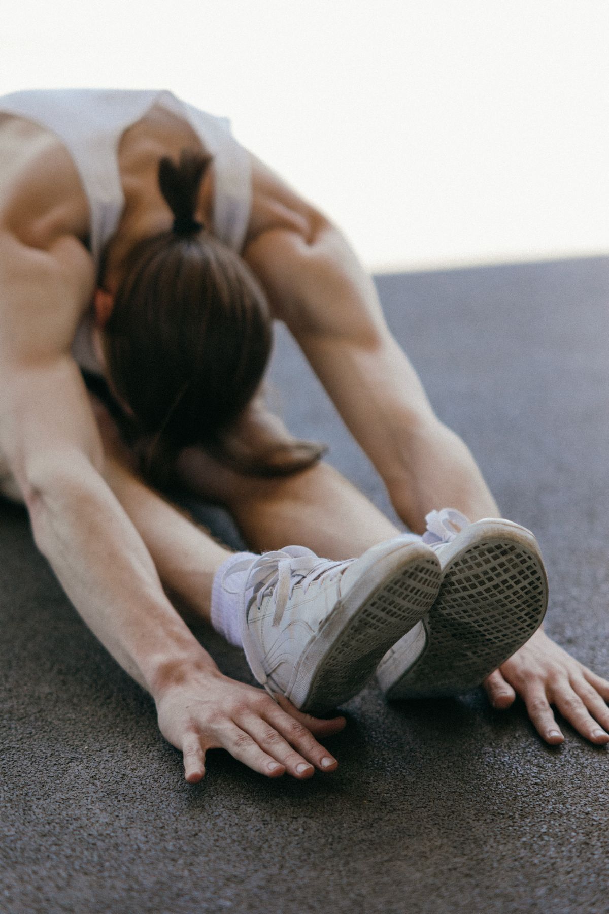 Person performing a stretch on a gym floor