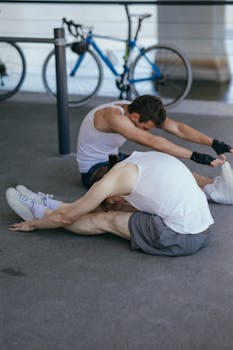 Two men in athletic wear stretching outdoors, promoting fitness and wellness.