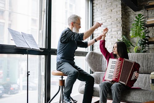 A Man Teaching a Girl How to Play an Accordion