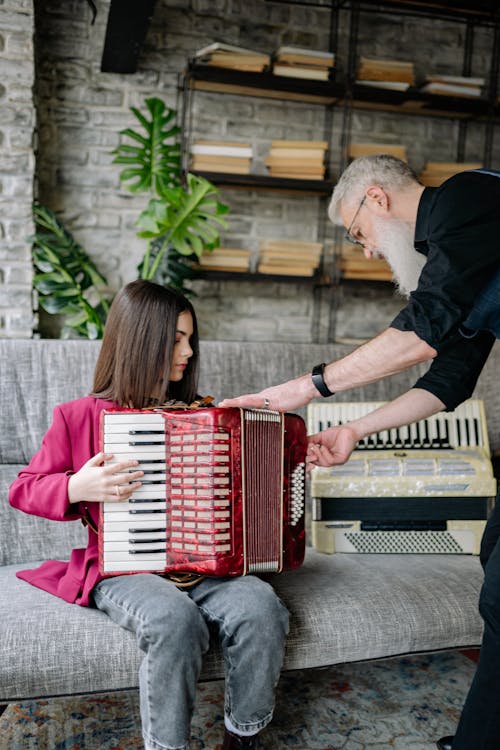 A Man Teaching a Girl How to Play an Accordion