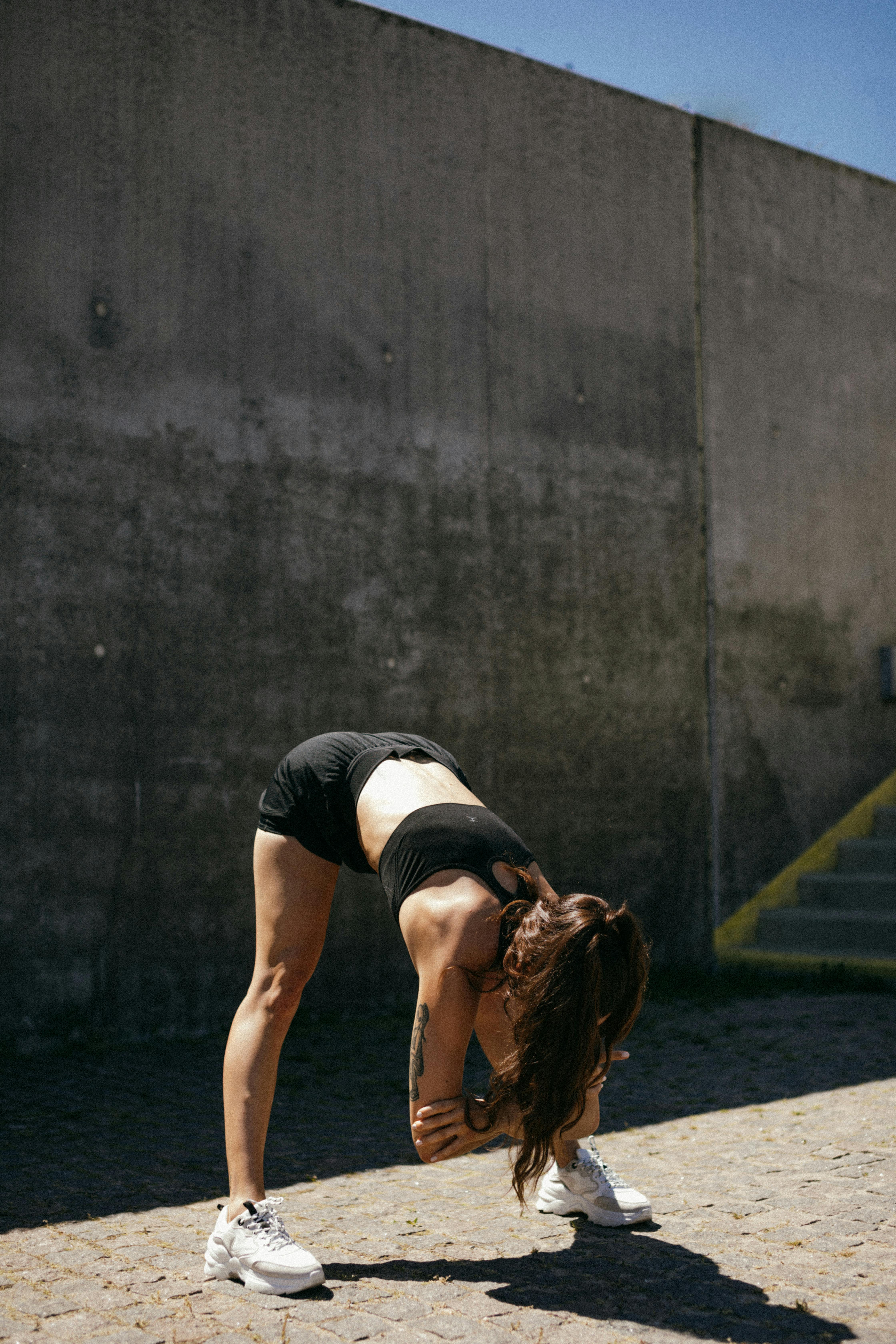 Black sportswoman stretching arms in studio · Free Stock Photo