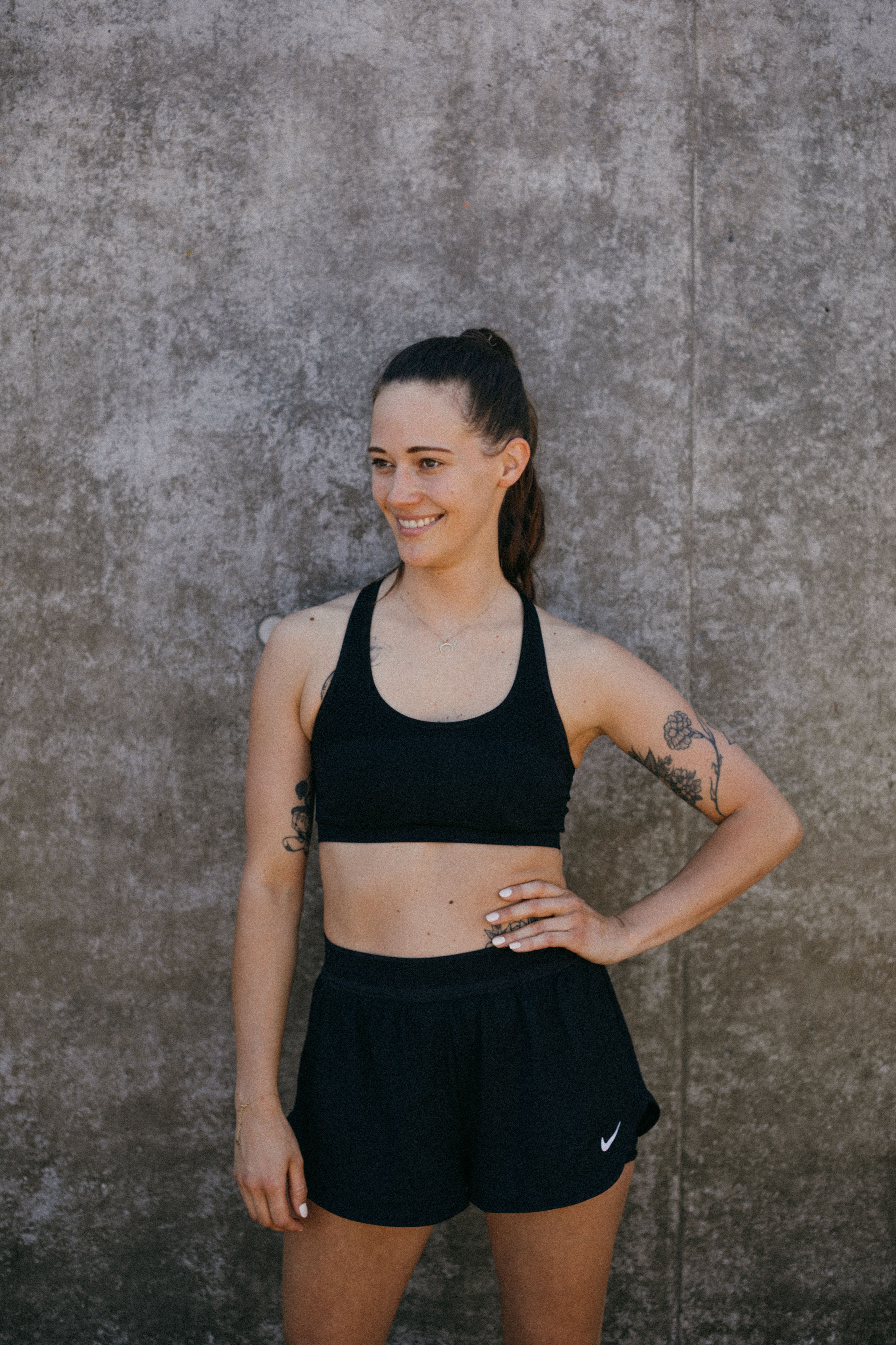 Fit woman in black activewear posing outdoors. Health and wellness concept.