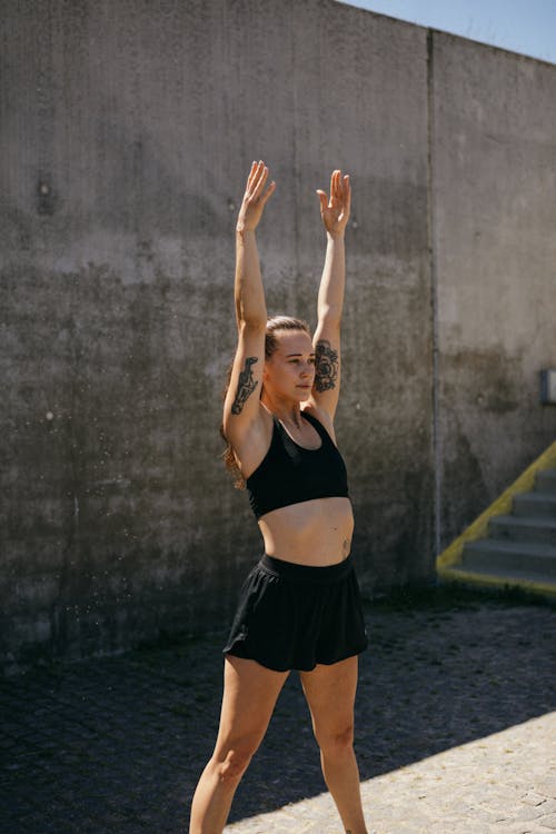 Woman in Black Sports Bra Stretching Her Arms