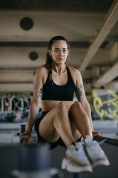 Young woman focuses on strength training on parallel bars in an urban gym setting.