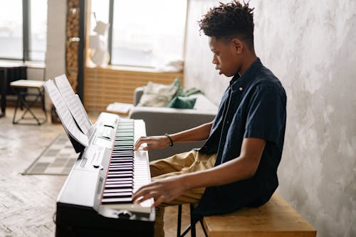 Free Boy in Blue Polo Playing the Piano Stock Photo