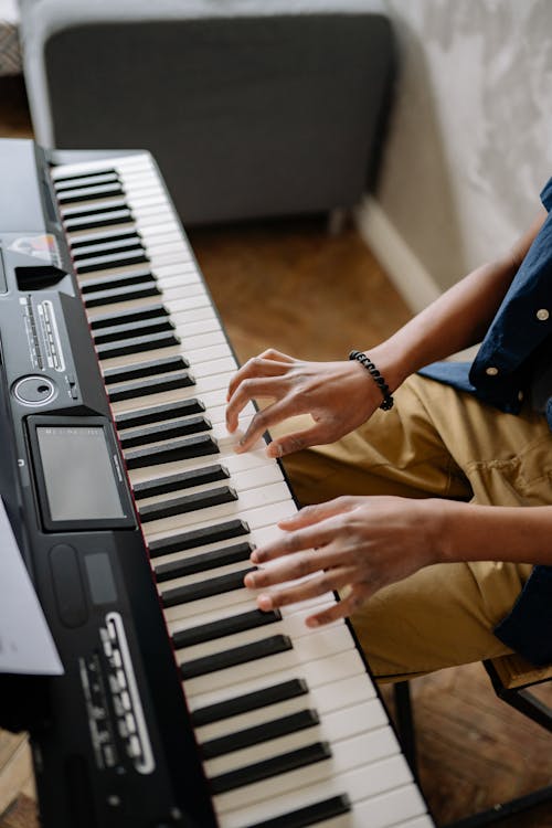Close-Up Photo of a Person's Hands Playing an Electronic Keyboard