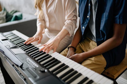 Woman Playing Piano Beside a Person