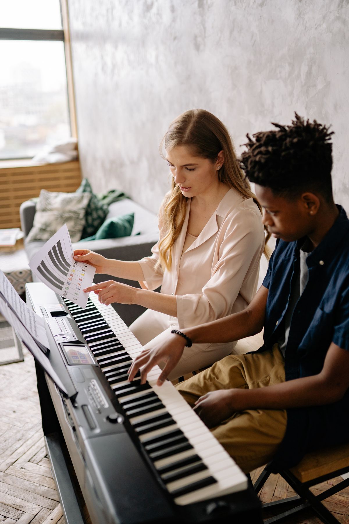 Woman teaching a boy how to play piano